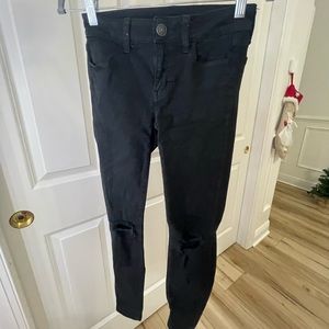 Black skinny jeans with holes on the knees, not very worn